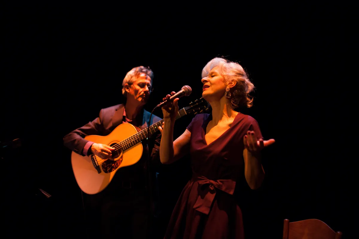 Man sieht Letizia Fiorenza singen und ihren Mann David Sautter Gitarre spielen.
